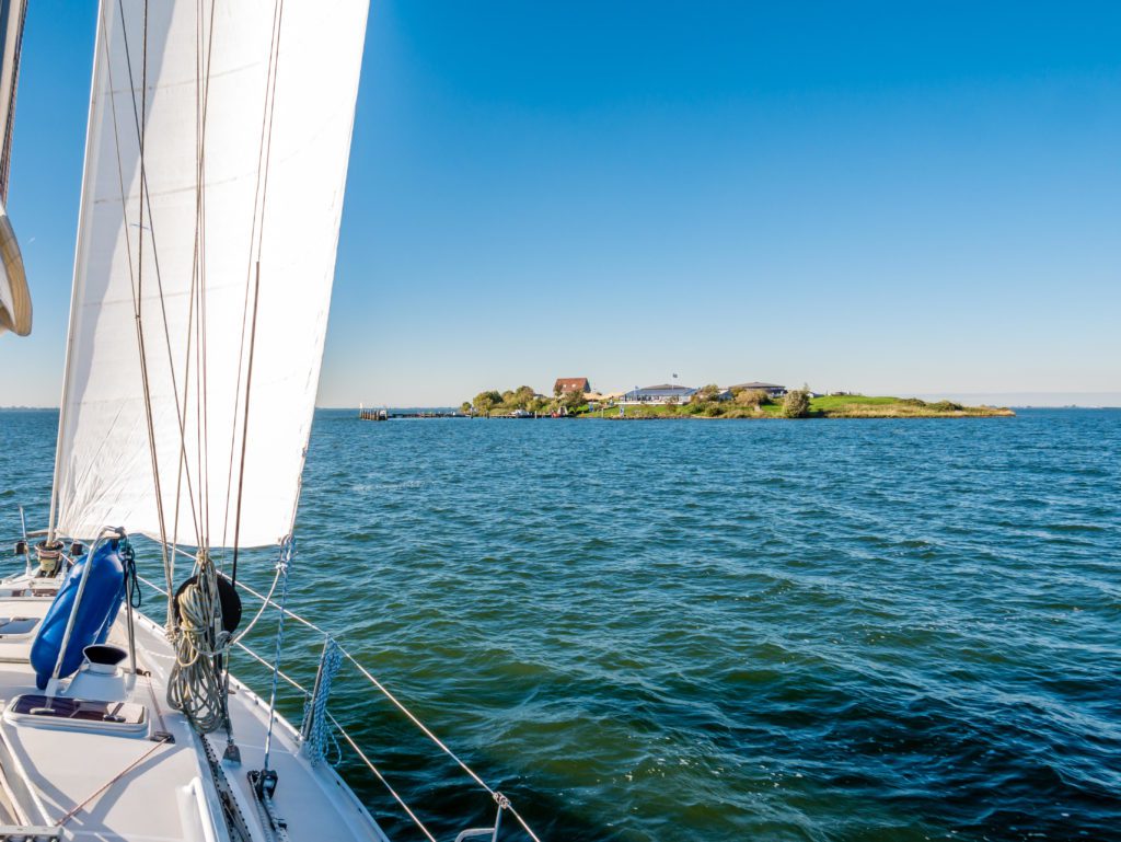 Sailing boat to the island of Fort Pampus on the IJmeer lake near Marina Muiderzand, one of the most beautiful marinas in the Netherlands