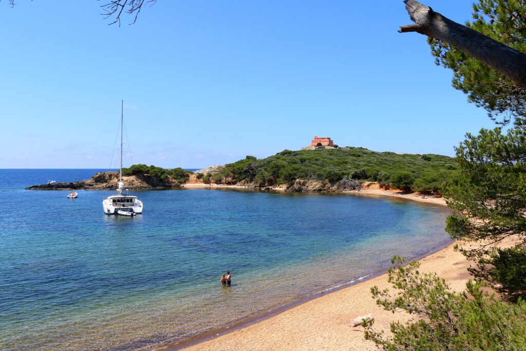 Île de Porquerolles, Côte d'Azur. Blick auf den Strand Noire du Langoustier mit dem Fort du Langoustier auf der Spitze des Hügels.